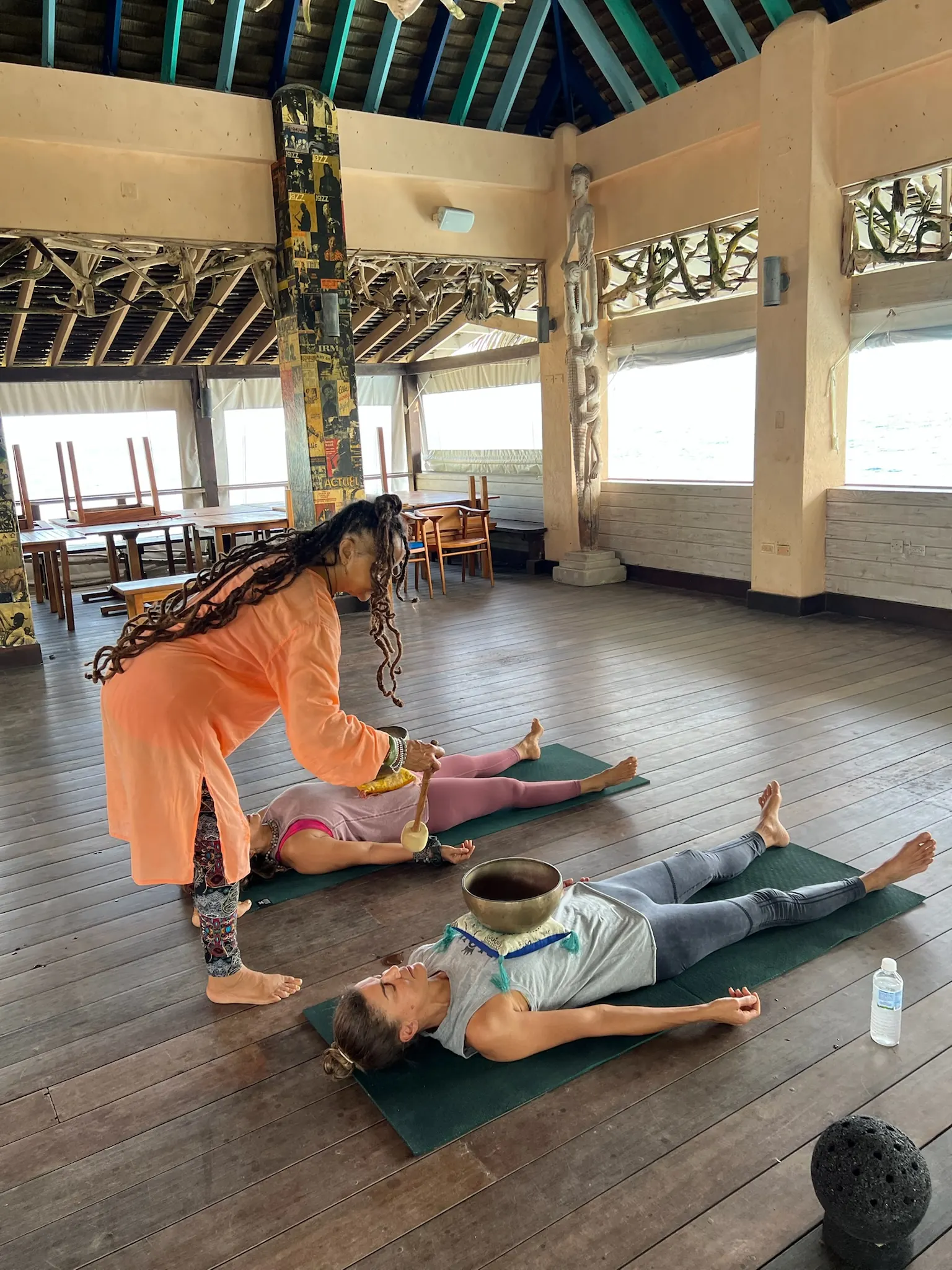 Cierre con cuencos tibetanos sobre las personas en savasana.